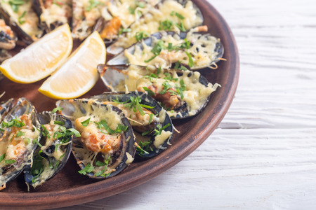 Mussels baked with cheese and parsley . Seafood backgroundの写真素材