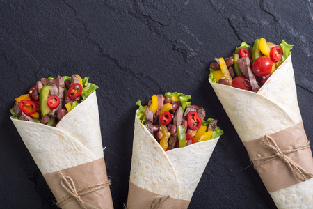 Burrito with beef , salad , tomato,  peppers and haricot . Food backgroundの写真素材