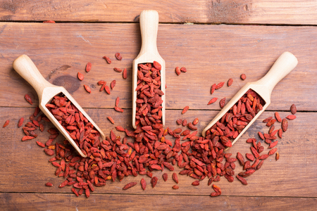 Goji berries in wooden spoon . Superfood backgroundの写真素材