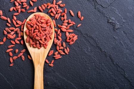 Goji berries in wooden spoon . Superfood backgroundの写真素材