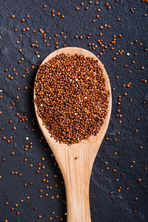 Red quinoa in spoon on wooden background . Superfood の写真素材