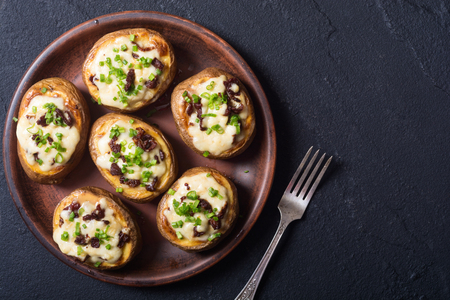 Baked potato stuffed with cheese , bacon and onionの写真素材