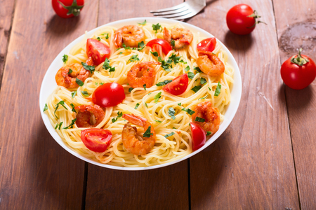 Pasta . Spaghetti with shrimps, tomatoes and parslley . Seafood backgroundの写真素材