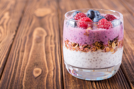 Chia yogurt with granola and berries  ( blueberries , raspberry
 ) in glassの写真素材