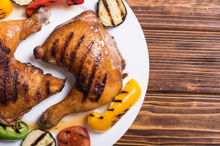 Grilled chicken legs with vegetables . Food backgroundの写真素材