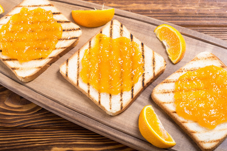 Homemade orange jam toast on wooden table . Fruit breakfastの写真素材