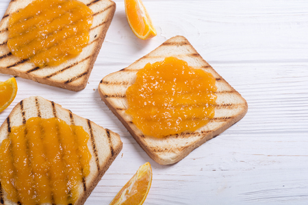 Homemade orange jam toast on wooden table . Fruit breakfastの写真素材