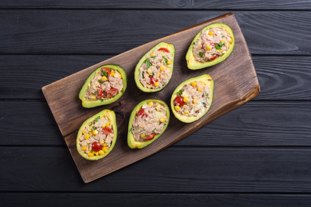Avocado stuffed with salad from vegetables , parsley and eggs