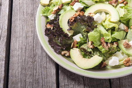Healthy salad with avocado , walnuts and cheese . Vegan foodの写真素材