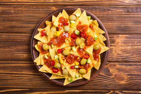 Traditional mexican food . Nachos with sauce salsa , olives , chili peppers and avocadoの写真素材