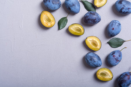 Fresh plums in bowl on wooden table . Fruit backgroundの写真素材