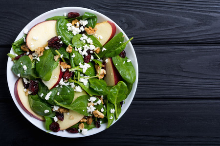 Autumn spinach salad with apple , cheese , walnut and dried cranberry . Healthy vegetarian foodの写真素材