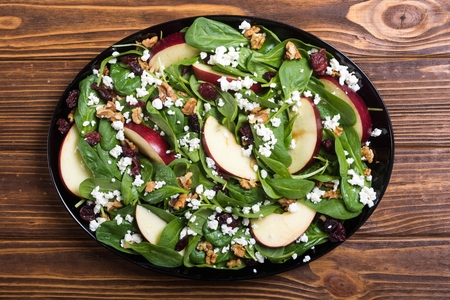 Autumn spinach salad with apple , cheese , walnut and dried cranberry . Healthy vegetarian foodの写真素材