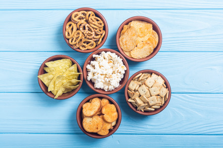 Frame . Mix of snacks : pretzels , crackers , chips nachos and pop cornの写真素材
