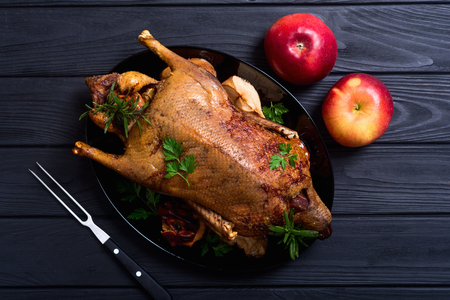 Roast baked duck . Christmas food on wooden backgroundの写真素材