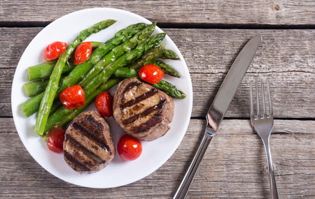 Grilled filet mignon with asparagus and tomatoes . Beef sreak on rustic backgroundの写真素材