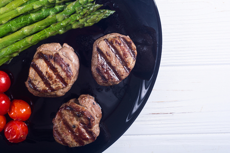 Grilled filet mignon with asparagus and tomatoes . Beef sreak on rustic backgroundの写真素材
