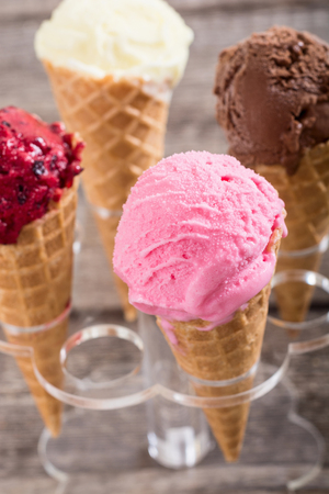 Ice cream waffle cones with berries , chocolate and vanillaの写真素材