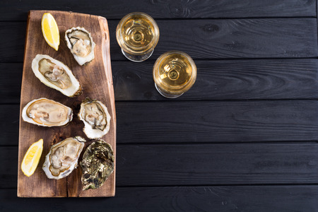 Fresh Oysters with lemon and white wine  . Seafood background