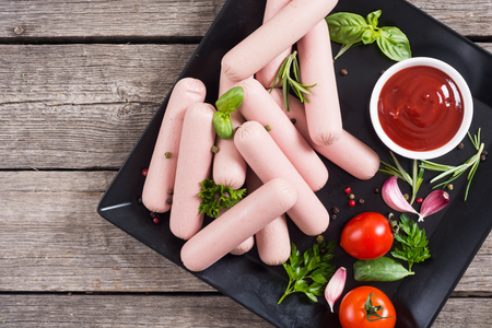 Raw beef sausages with pepper , herbs and ketchup . Food backgroundの写真素材