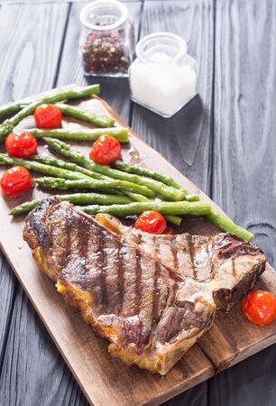 Grilled T-bone steak with asparagus and cherry tomatoes . T bone beefの写真素材