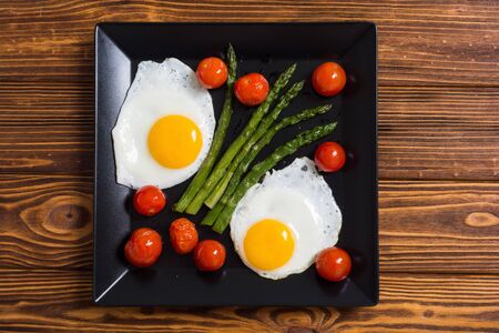 Healthy breakfast with eggs , asparagus and tomatoes . Vegetable backgroundの写真素材