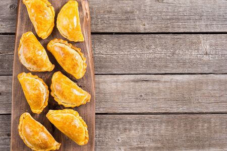 Latin American baked beef empanadas with sauces . Food background