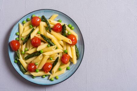 Penne pasta salad with asparagus , tomatoes and peas . Food backgroundの写真素材