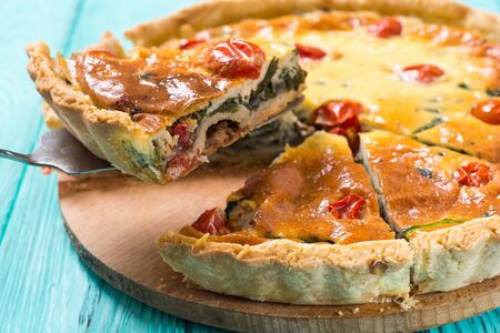 Traditional French pie . Spinach Quiche lorraine with tomatoesの写真素材