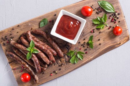 Grilled sausages with tomatoes , pepper and rosemary`. BBQ food background