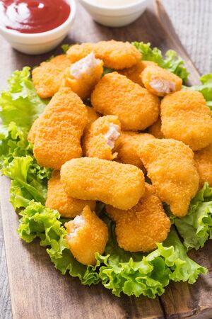 Chicken golden nuggets on wooden board. Unhealthy fast foodの写真素材