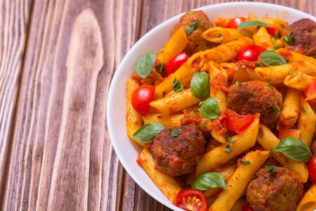 Italian penne pasta with meatballs and tomatoes . Food backgroundの写真素材