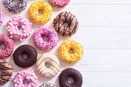 assorted donuts with chocolate frosted, pink glazed and sprinkles . Top viewの写真素材