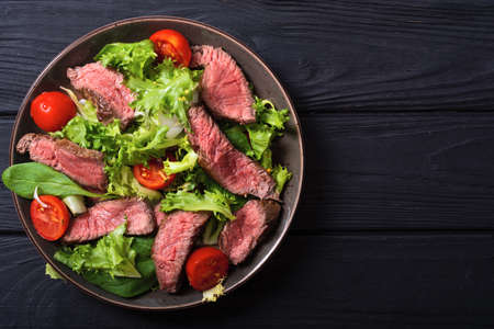 Salad with grilled beef medium roast. On wooden backgroundの写真素材