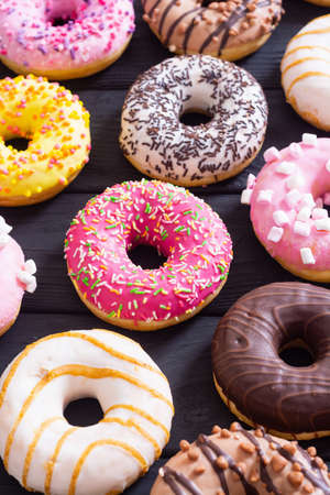 assorted donuts with chocolate frosted, pink glazed and sprinkles. Top viewの写真素材