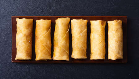 Asian food. Fried spring rolls with vegetables on rustic background