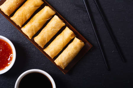 Asian food. Fried spring rolls with vegetables on rustic background