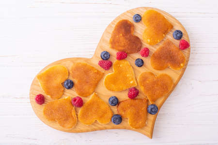 Mini pancakes hearts with berries. Delicious breakfast. Food background. Valentine's dayの写真素材