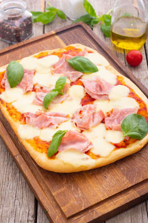 Traditional italian pizza with ham mozzarella and basil. Pinsa romanaの写真素材