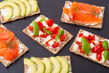 Crispbread with salmon avocado mozzarella and tomatoes. Healthy diet nutrion for vegan