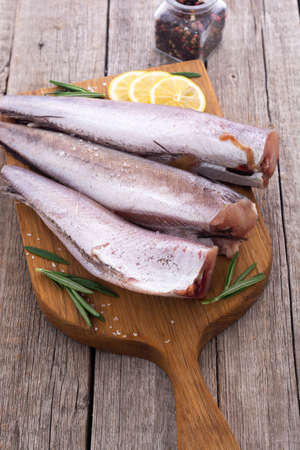Raw hake on wooden background . ready to cooking
