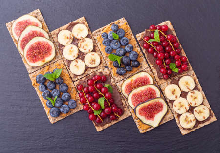 Crispbread with banana  blueberry redcurrant and figs .  Healthy diet food