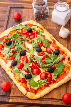 Traditional Italian pizza with vegetables tomatoes cherry, olives and arugula. Pinsa Romanaの写真素材