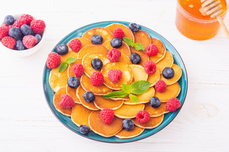 Mini pancakes with berries. Delicious breakfast. food backgroundの写真素材