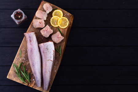 Raw hake on wooden background. ready to cooking top view