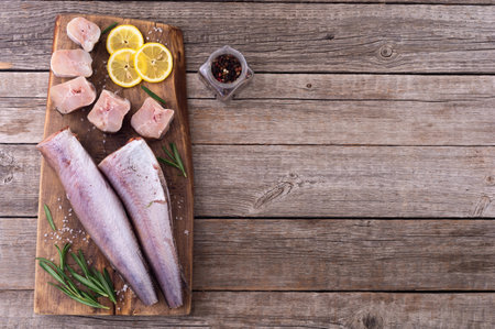 Raw hake on wooden background. ready to cooking top view