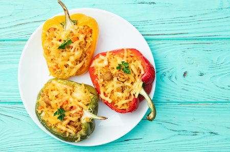 Baked stuffed pepper (paprika) with rice, carrot and meat. Top view on rustic background photographyの写真素材