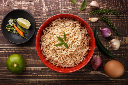 noodle in bowl and ingredients on wood background top viewの写真素材