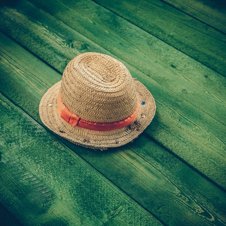 Summer panama straw hat isolated on green wood table - vintage coaster