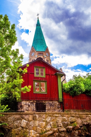 church behind a red old houseの写真素材